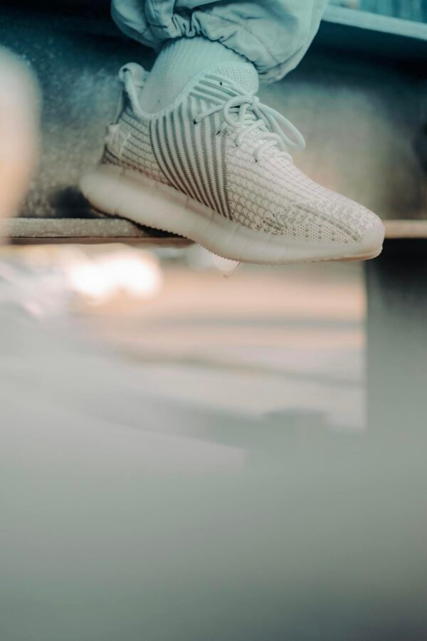Close-up of stylish white sneakers in an urban setting capturing youthful fashion vibes.