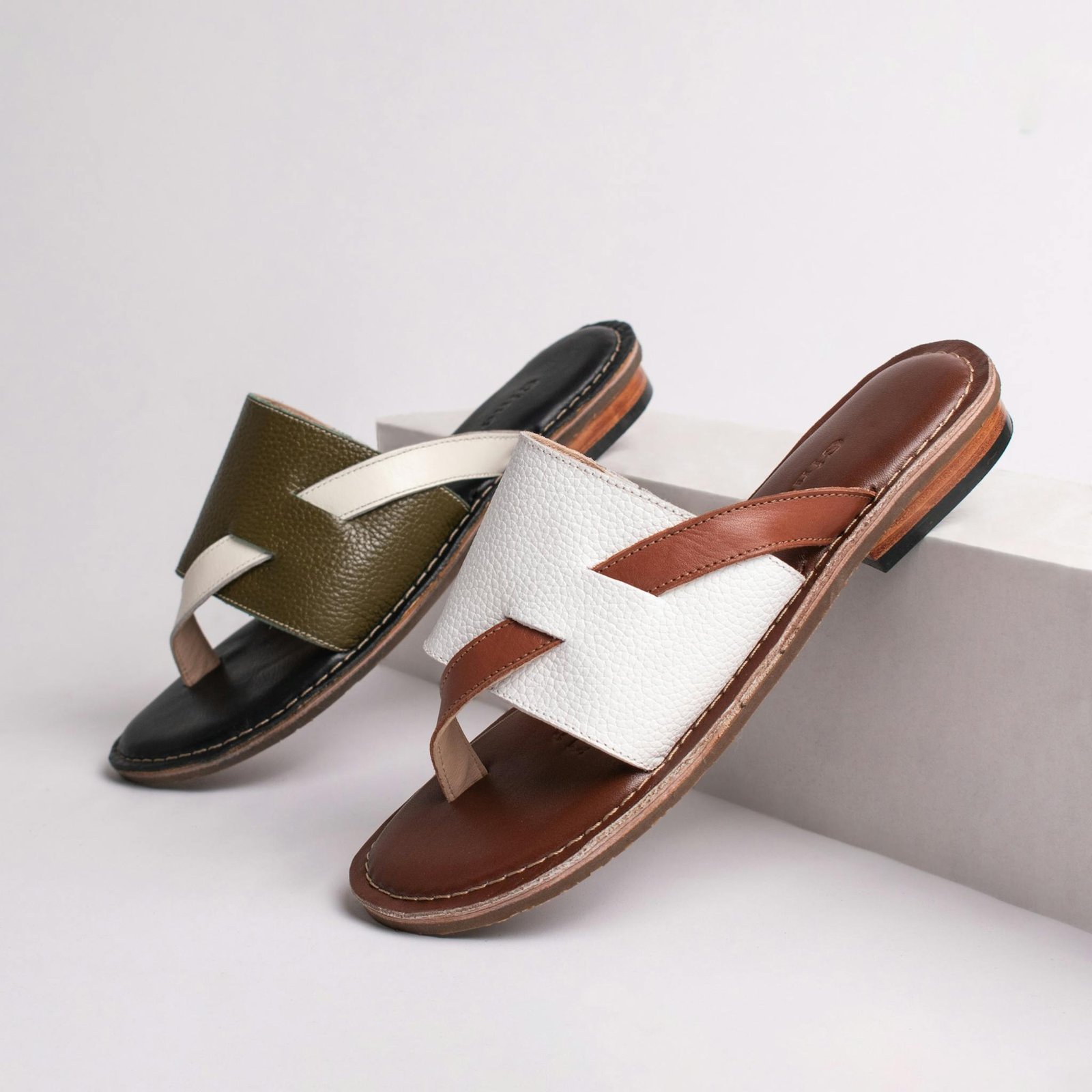 Elegant leather sandals in a modern, stylish product shot with a minimalist background.