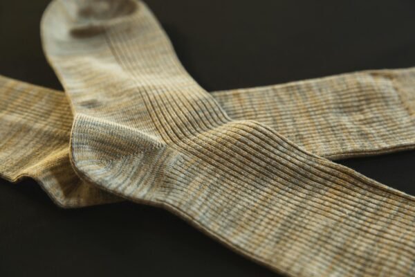 From above of pair socks made of soft material placed above each other on black background