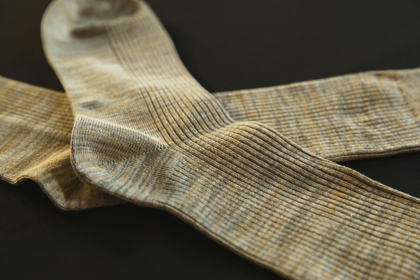 From above of pair socks made of soft material placed above each other on black background