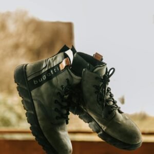 Stylish Bugatti boots suspended against a rustic background, perfect for outdoor enthusiasts.