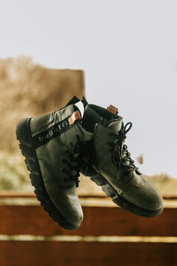 Stylish Bugatti boots suspended against a rustic background, perfect for outdoor enthusiasts.